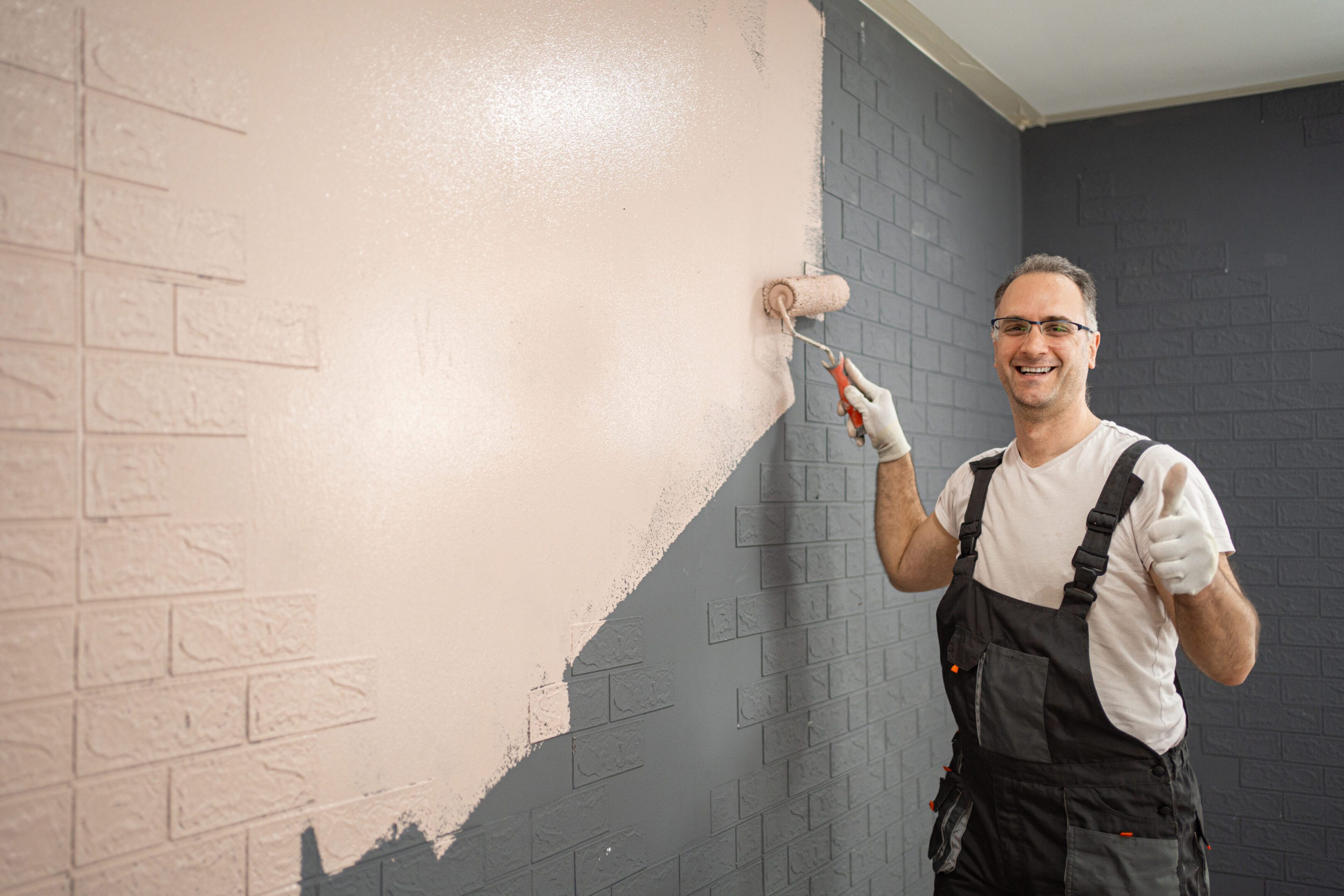 Happy mid adult men painting apartment wall using paint roller A Complete Guide to Choosing the Right Paint for Homes